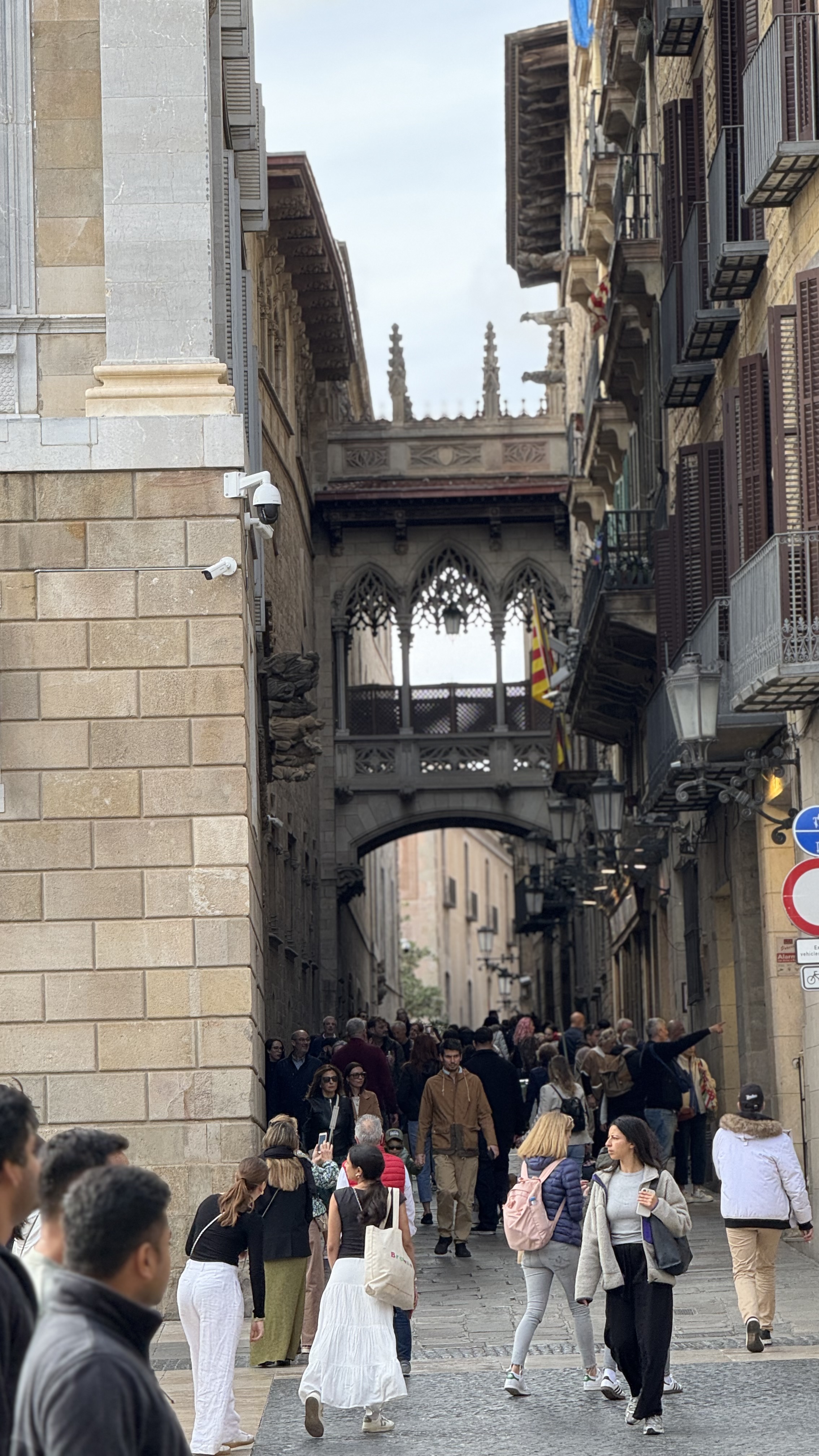 Crowds walking beneath the Pont del Bisbe bridge in Barcelona's Gothic Quarter